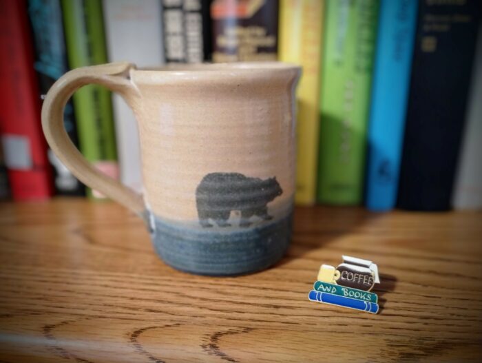 Coffee cup and books besides a Coffee and Books pin